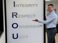 Marty McKinley proudly points to the company core values in our Giroux Glass Phoenix office.